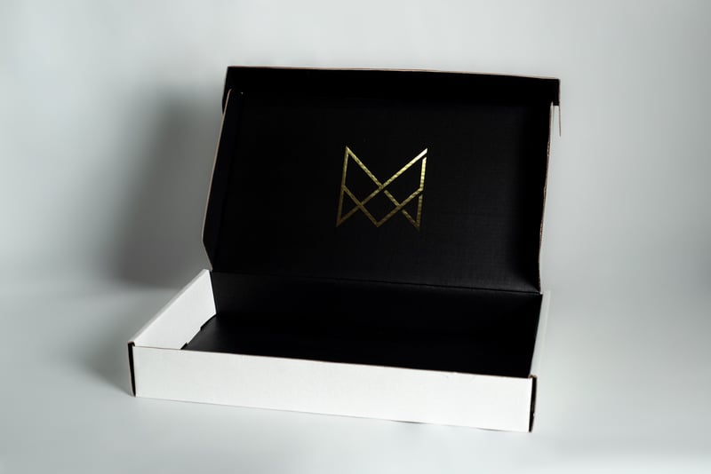 Caja abierta negra y blanca de VALEMMA con interior personalizado.