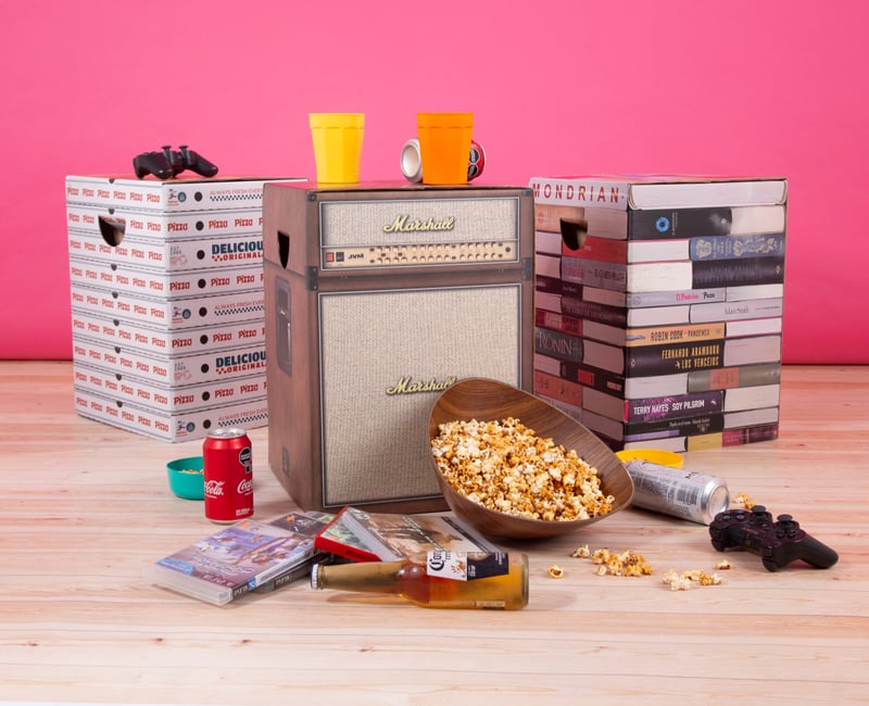 Mueble de cartón Cartón Nomade modelo amplificador Marshall junto a muebles gráficos de libros.