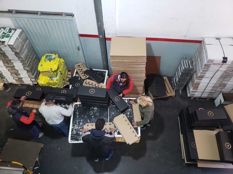 Operarios armando exhibidores de cartón en planta de SellerPack.