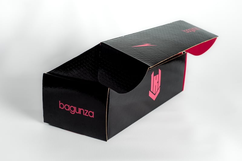 Caja Bagunza abierta mostrando interior rosa fucsia con grafismo de marca.
