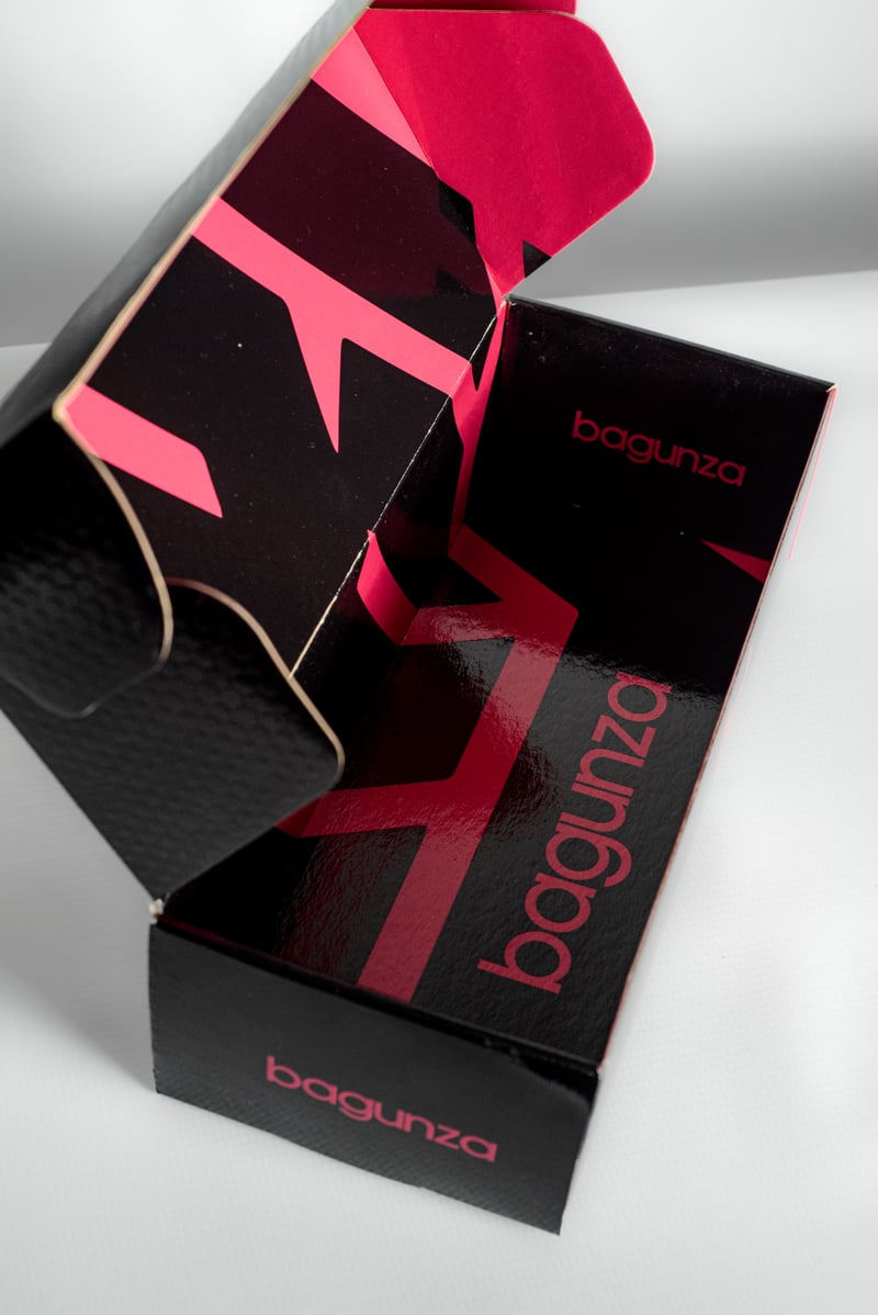 Caja Bagunza abierta con interior gráfico rosa y negro.