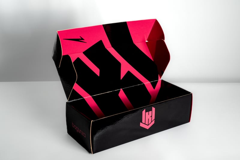Caja negra Bagunza con logo rosa y textura visible.