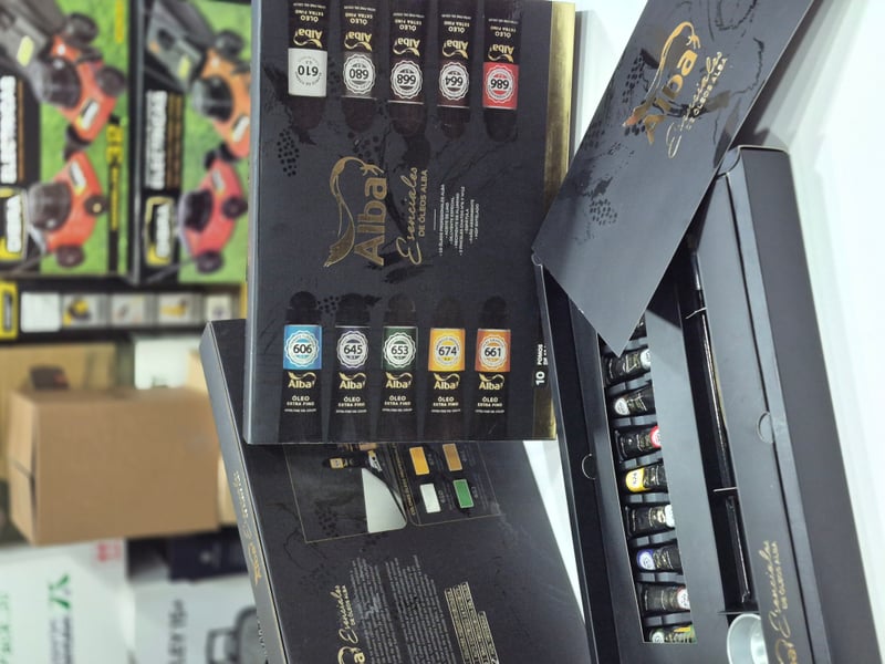 Caja Alba Esenciales de Óleos abierta con pomos de pintura.